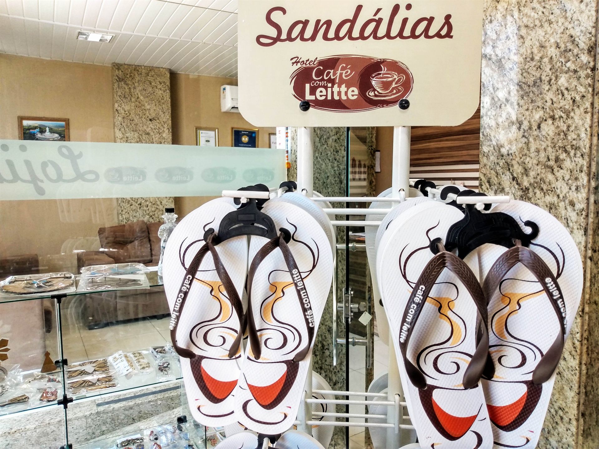 Expositor da lojinha com as sandálias exclusivas Café com Leitte, sob a placa Sandálias