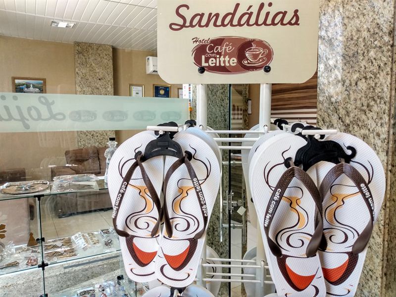 Expositor giratório com sandálias de dedo estampadas com a marca Café com Leitte